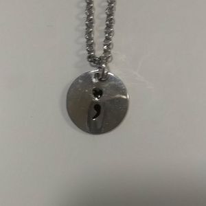 Silver necklace with logo for suicide prevention. Reminder for you and others.